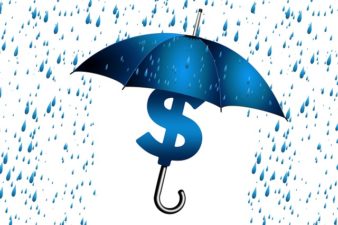 an umbrella protecting a dollar sign from the rain